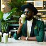 A stylish person at a modern café sipping a kratom-infused drink, surrounded by wellness and fashion elements, embodying elegance and contemporary lifestyle.